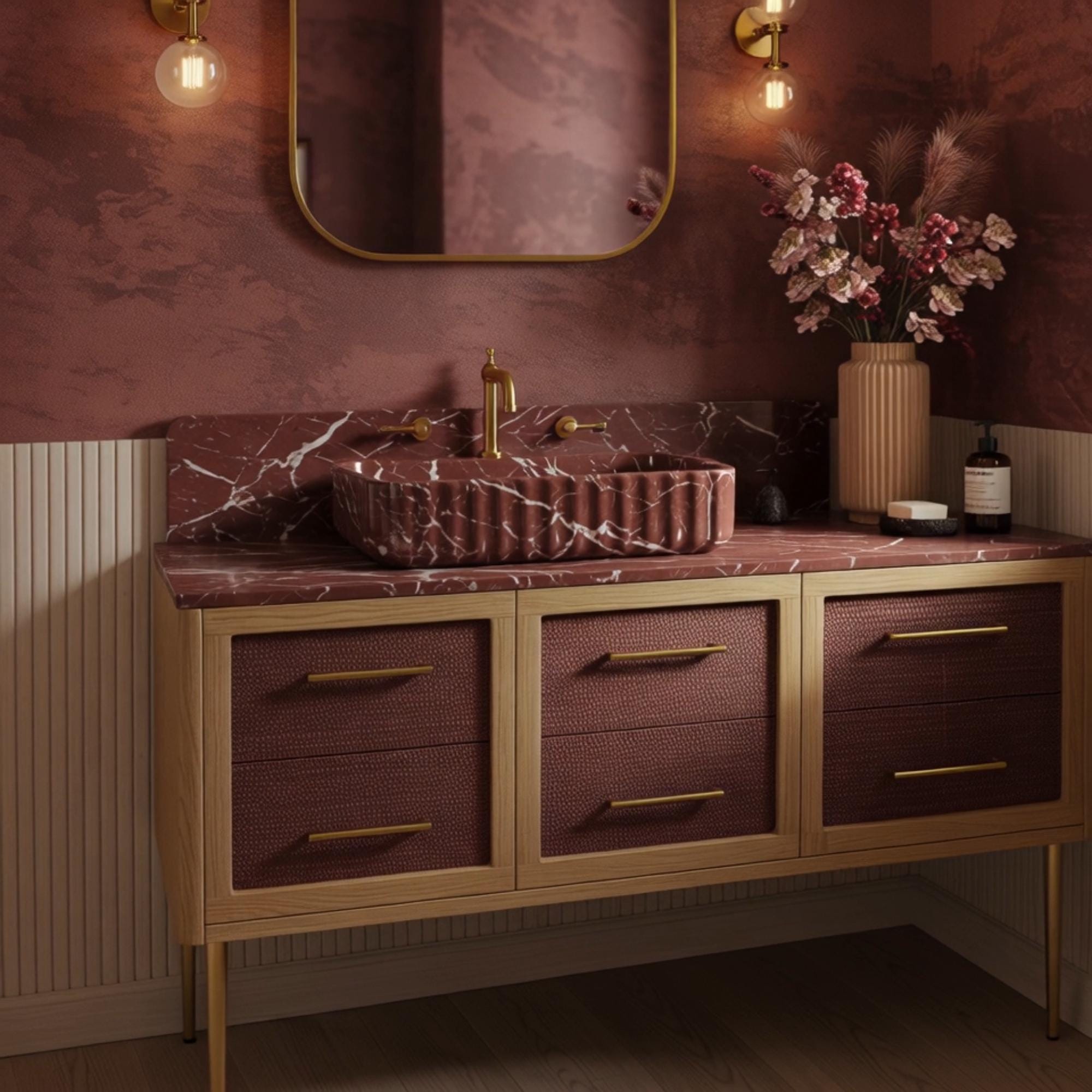 A Rosso Levanto marble console vanity with fluted detailing, combining warm wood textures and brass accents in a sophisticated bathroom atmosphere.
