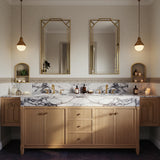 A Calacatta Viola double vanity with expressive purple veining, paired with a fluted oak cabinet and brass fixtures in an elegant, classic bathroom interior.
