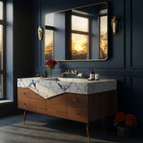 A Calacatta Viola marble vanity with a geometric V-shaped front, paired with a mid-century style walnut cabinet and brass hardware in an elegant bathroom.
