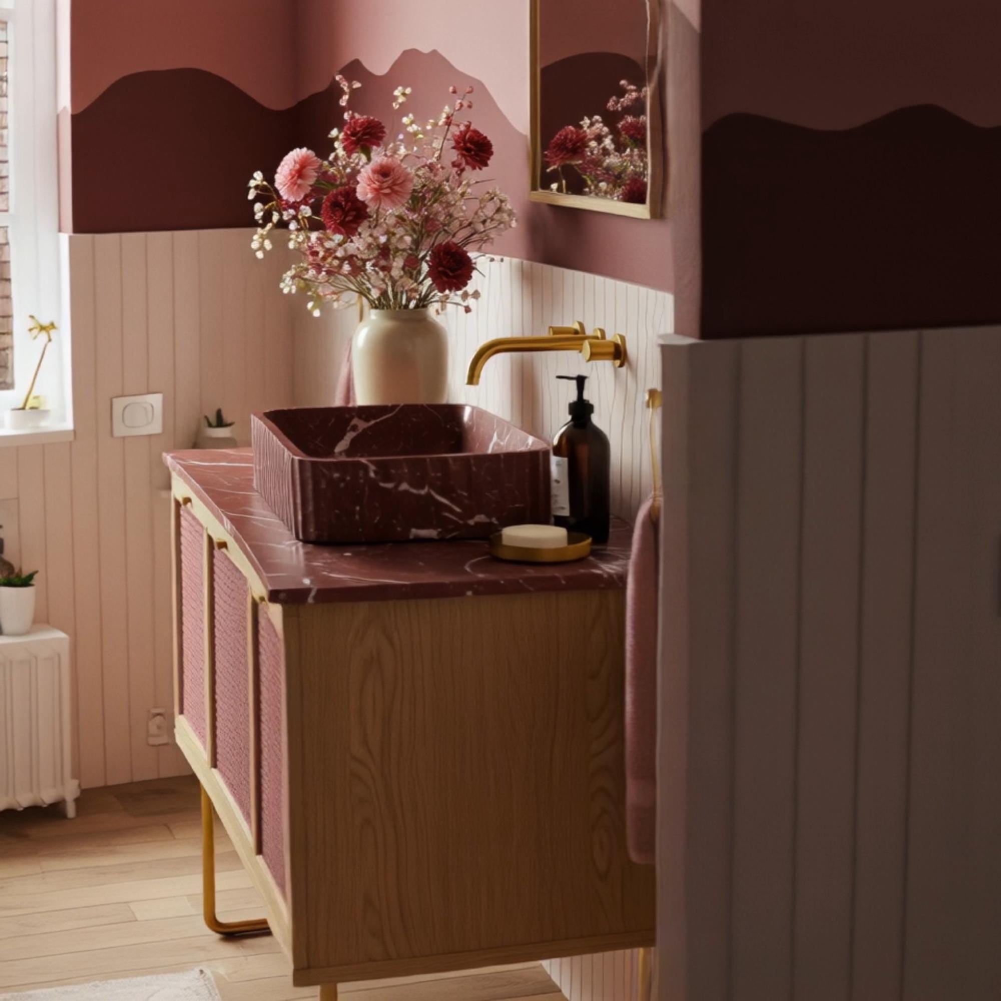 A red marble vanity crafted from natural stone, featuring a fluted sink and rattan-front wooden cabinet in a refined bohemian bathroom setting.

