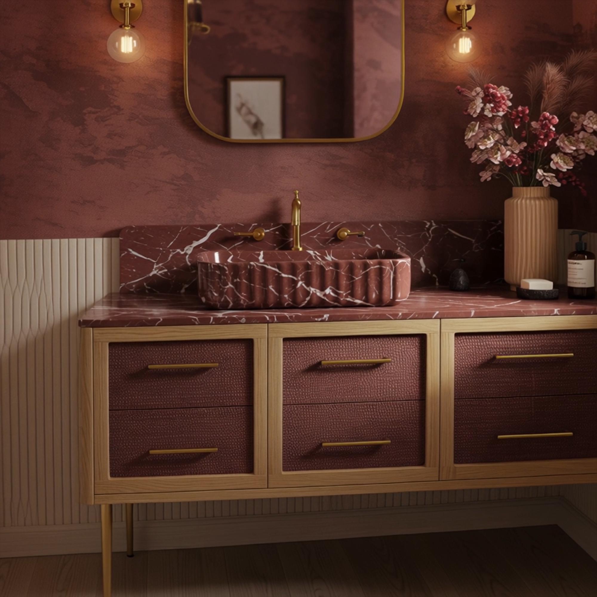 An Art Deco style marble vanity with a fluted Rosso Levanto sink, highlighting rich red tones and sculptural detailing in an elegant interior.
