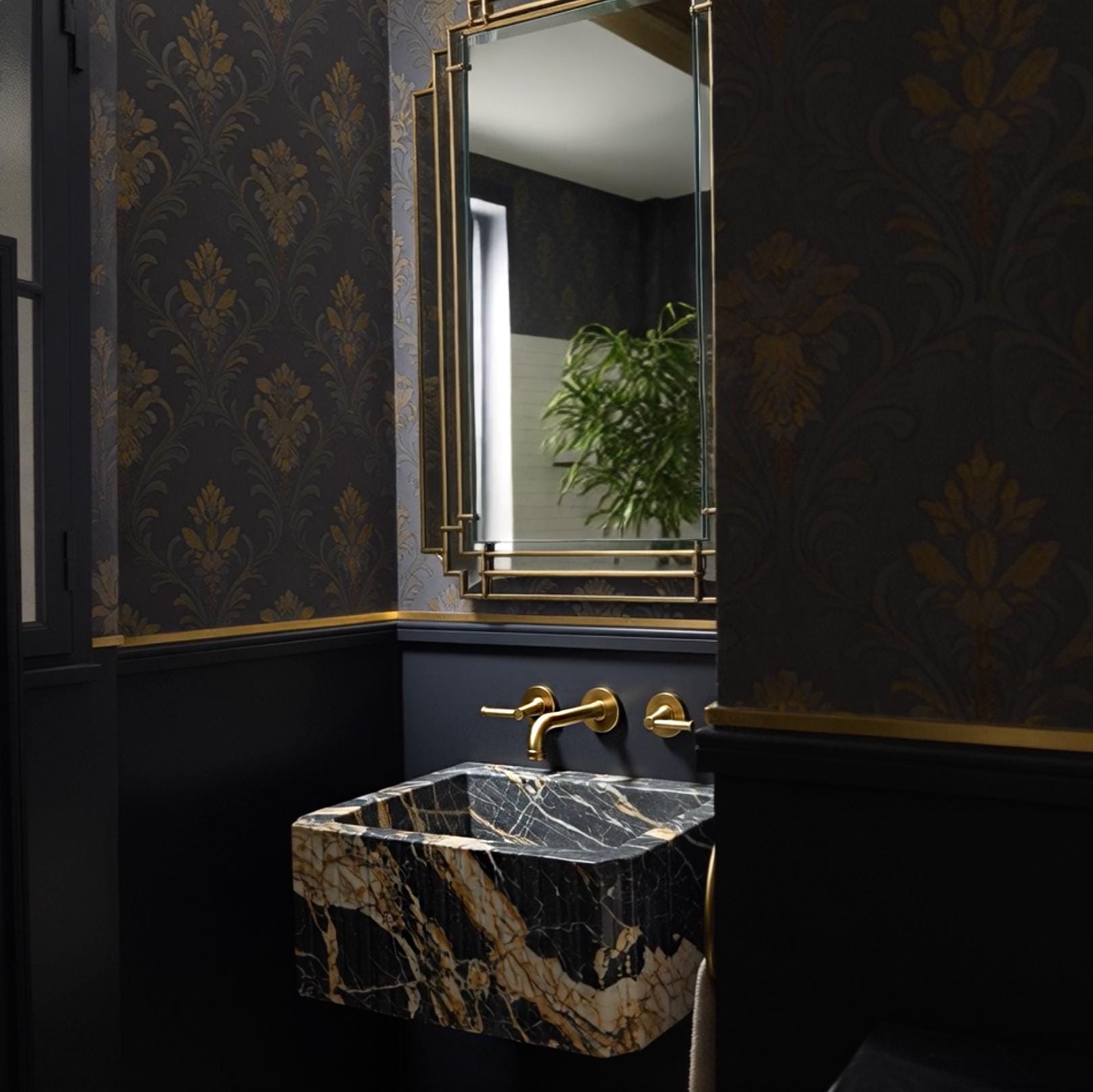 A Picasso marble wall-mounted sink crafted from natural stone, showcasing fluted detailing and chamfered edges in a refined luxury interior.
