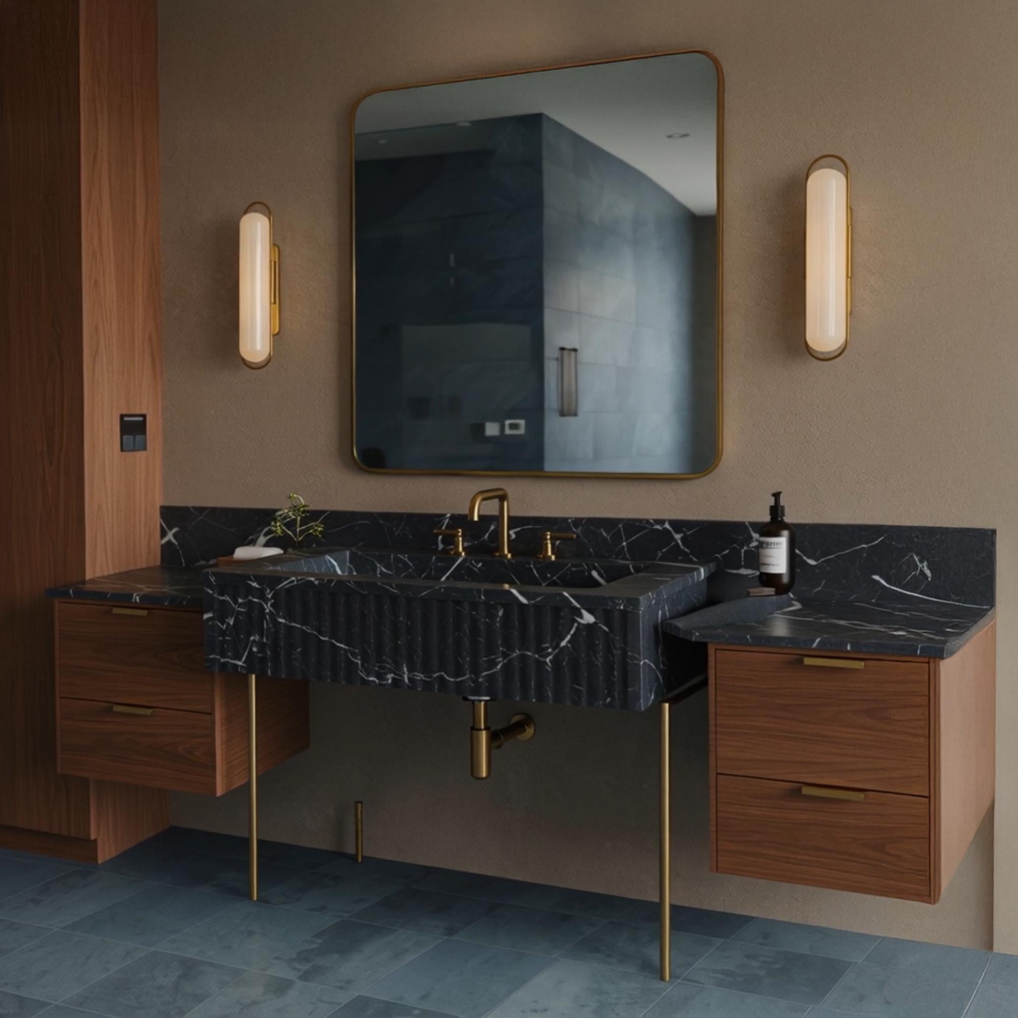 A Pietre Notte marble console crafted from natural stone, featuring fluted detailing, brass legs, and matching floating side cabinets.
