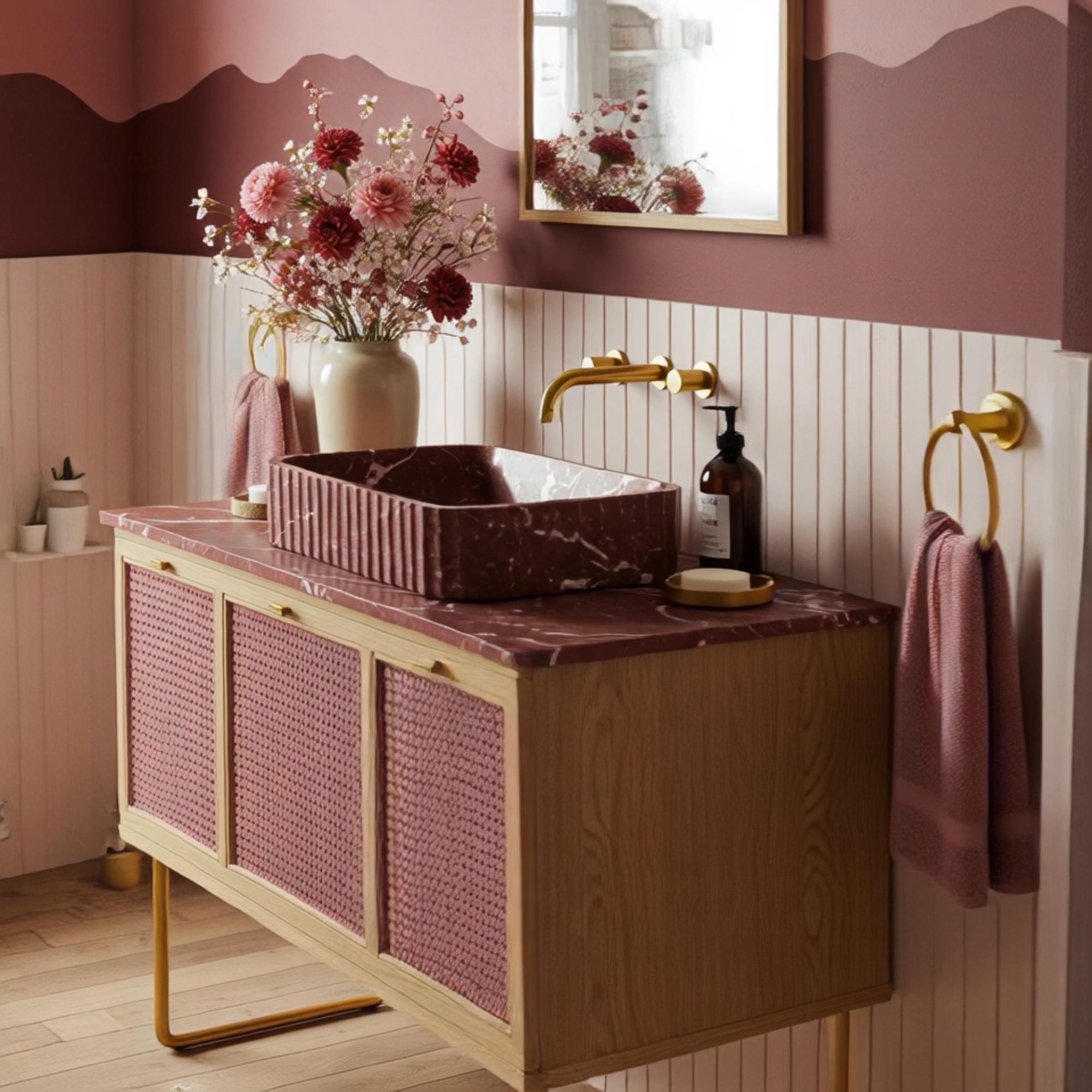 A bohemian-inspired marble vanity with a fluted red stone basin, combined with warm wood cabinetry and rattan panels in an elegant interior.
