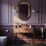 A soft pink marble console sink with a gold-toned stand, designed for refined and romantic bathroom spaces.